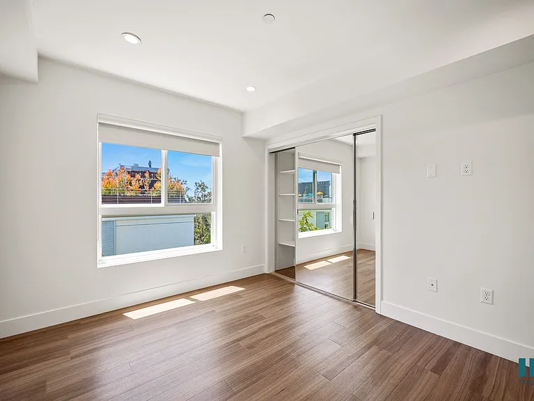 Bedroom with Vinyl Flooring, Recessed Lighting, and Mirrored Closet