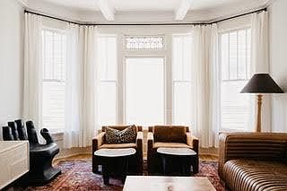 Large living room with lots of natural light and original windows