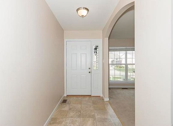 Entry leads to Formal Dining Room with arched entryways.