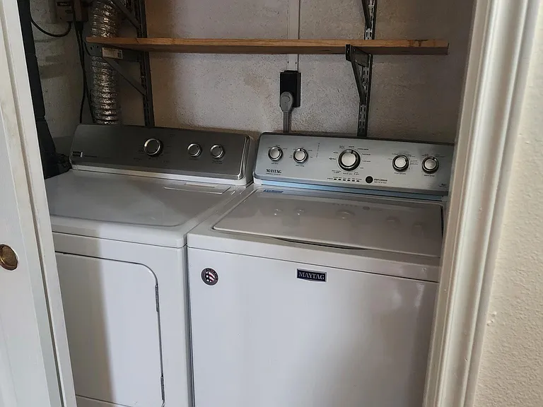 Full size washer and dryer behind closet doors.