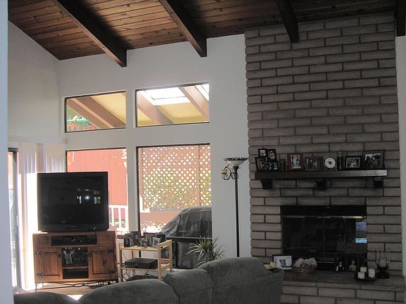 Living room with vaulted ceiling, wood beams and brick fireplace