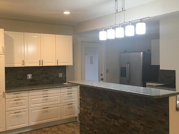 Granite kitchen countertops with Ikea cabinets, frig with ice maker and water in door, eating counter, all stainless steel appliances, frig, m/w, stove, d/w