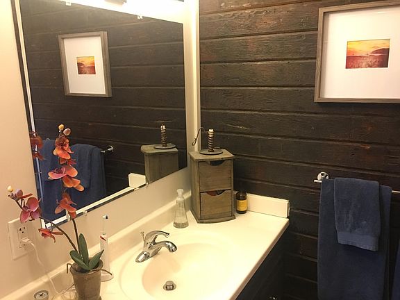 Primary bathroom with reclaimed wood paneling from original 1920s home.