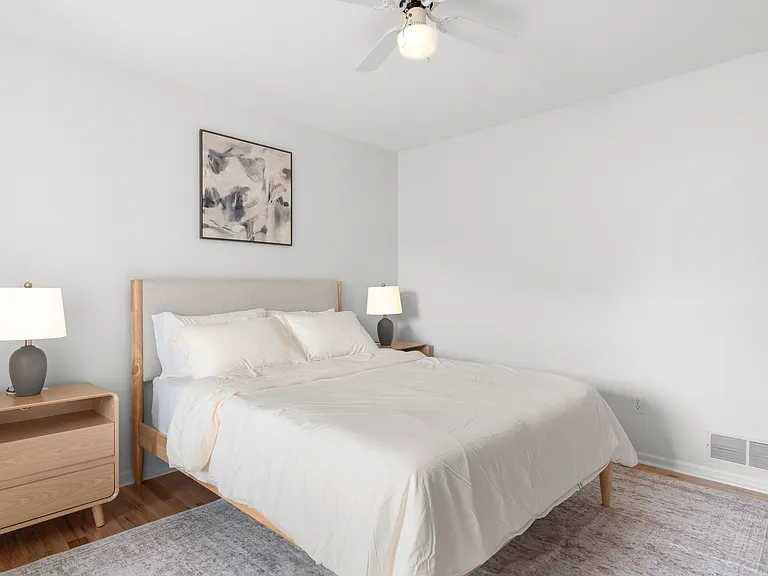 Inviting upper-level queen bedroom with clean linens, comfortable furnishings, and a dedicated writing desk.