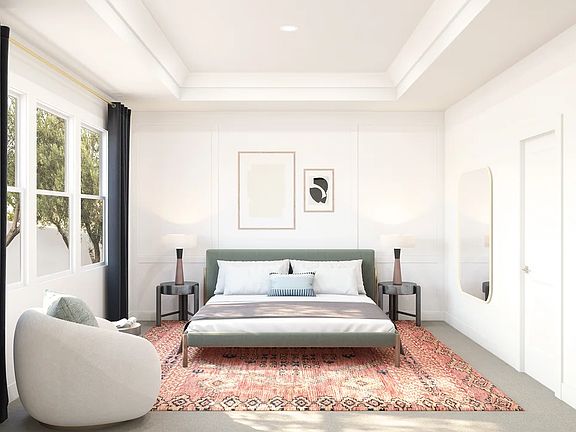 Primary suite with tray ceiling, crown moulding and decorative feature wall