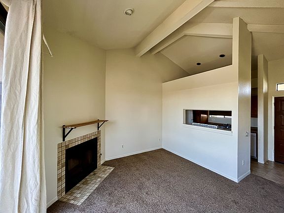 Open and bright living room with high ceiling, fireplace and balcony.