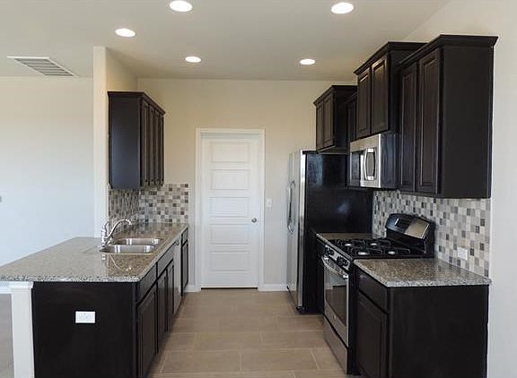 Granite countertops and stainless steel appliances. Refriger