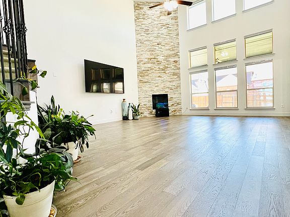 Bright and airy living area featuring high ceilings and large windows that flood the space with natural light