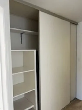 A large closet with sliding door and shelves for linen and towels.