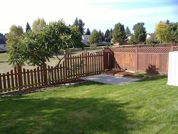 Back yard gate opens to grassed community sports field