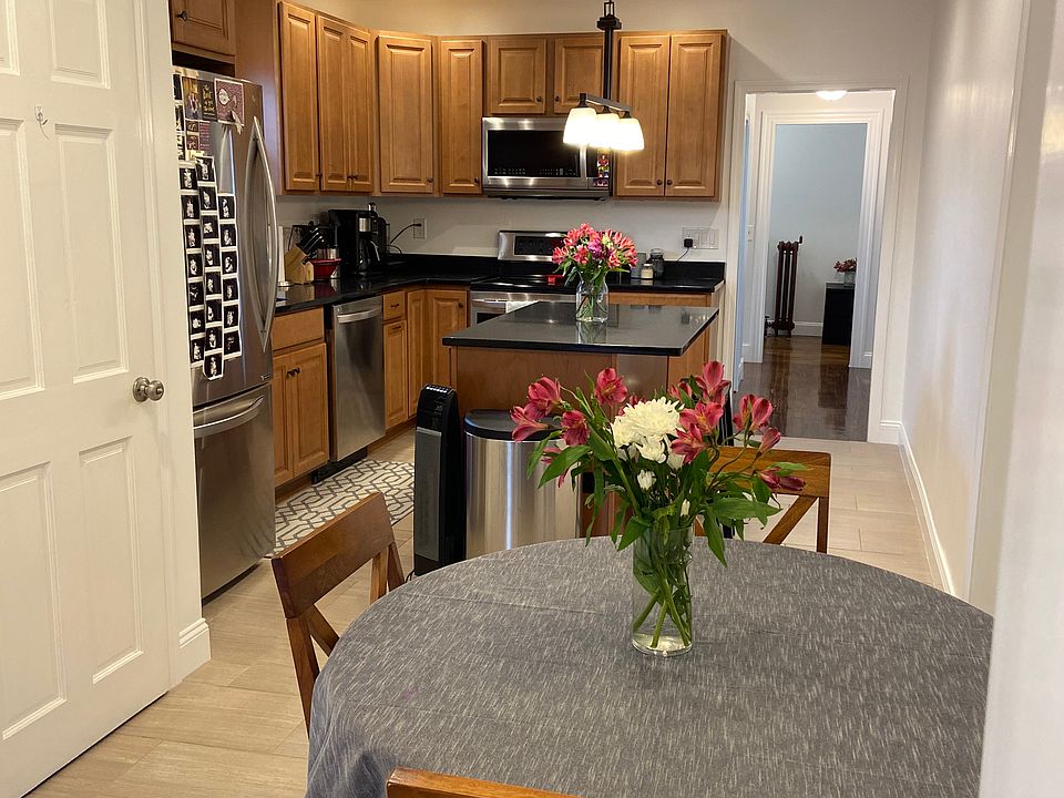 Updated kitchen w/36" maple wall cabinets and black quartz counters, two stool island, LG stainless steel appliances incl. dishwasher, garbage disposal, porcelain tile flooring, and recessed lighting on dimmers as well as high ceilings and eating nook.