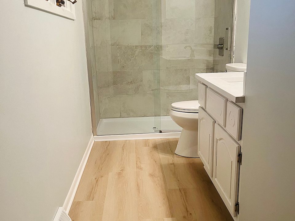 En Suite master bathroom, with floor-to-ceiling luxury porcelain tile, brushed nickel trim, and quartz vanity.