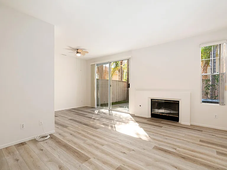 Spacious living / dining room with gas fireplace and access to back patio.