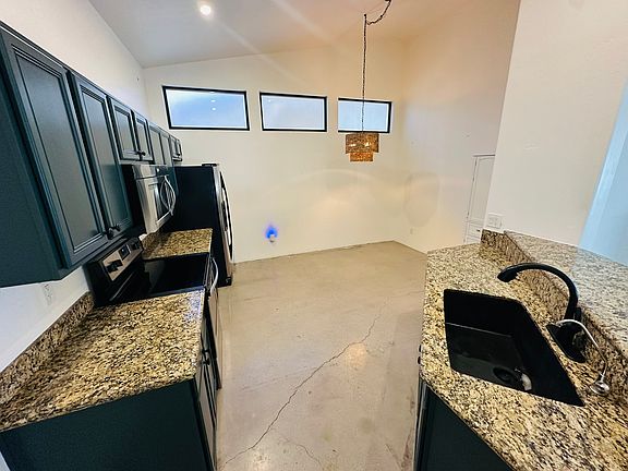 Large kitchen, plenty of counter space, large cabinets, dining nook area, and a new sink. High vaulted ceiling.