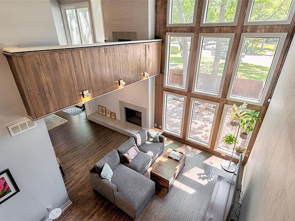 A birds eye view of the window wall from the second level of the home. The living room is below with entertainment area to the left.