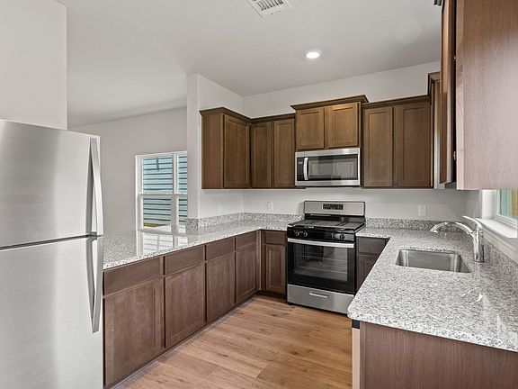 The kitchen of the Piper has gorgeous wood cabinetry and sprawling granite countertops.