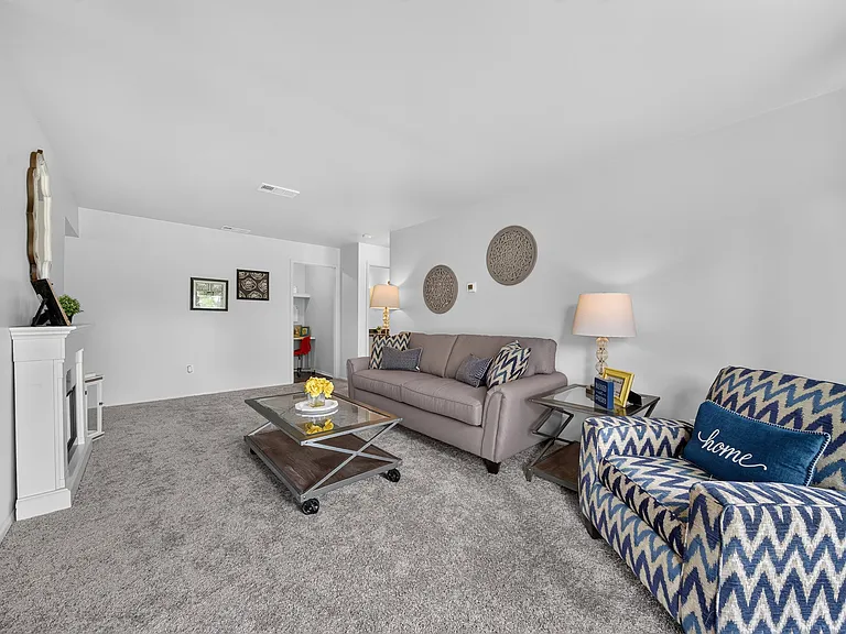 Elevated living room with a private balcony at Drawbridge Apartments in Harrison Township, MI.