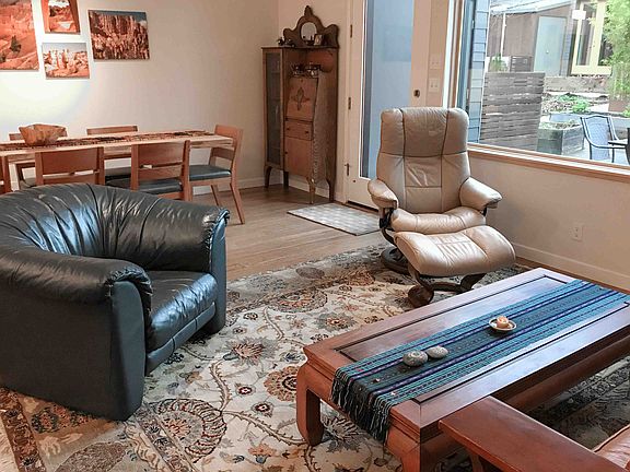 Living room with view through window to patio and garden area.