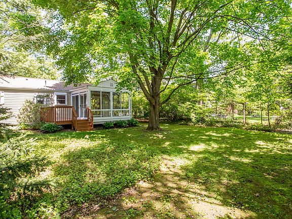 Rear yard with view of sunroom and deck