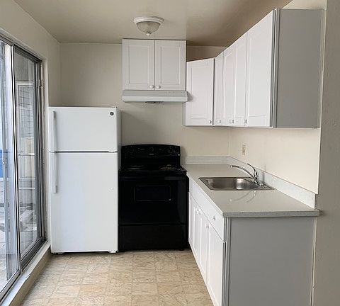 Kitchen with new cabinets, countertop, and range hood.