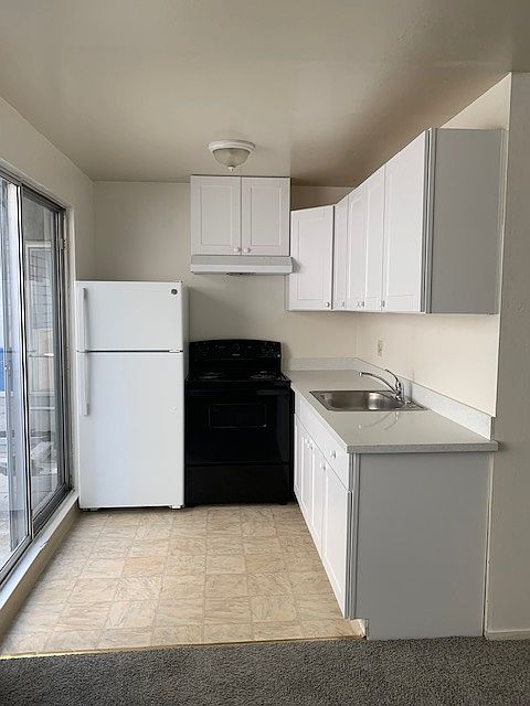 Kitchen with new cabinets, countertop, and range hood.