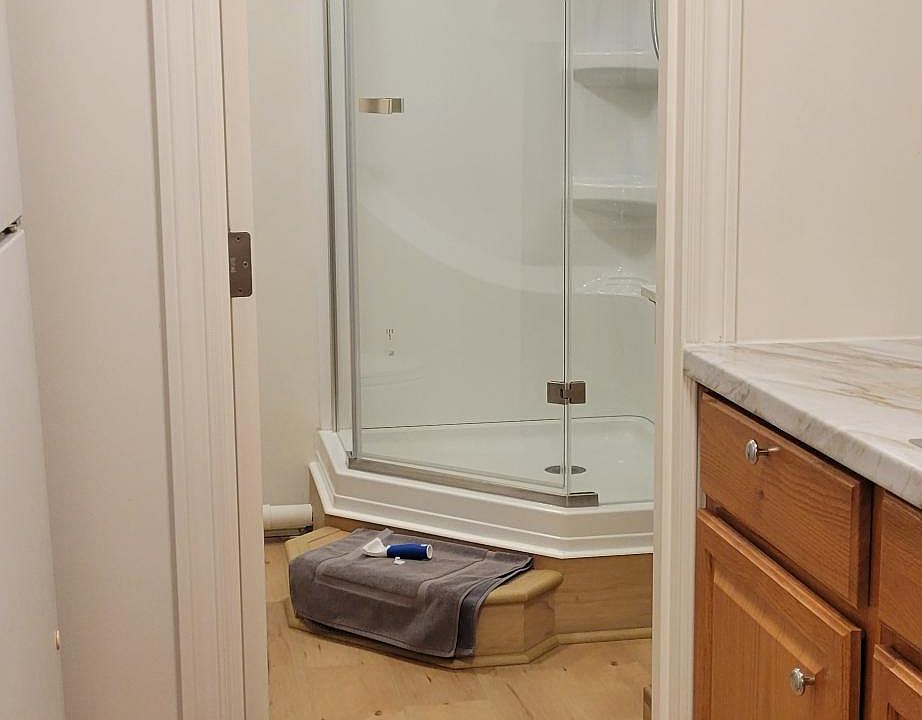 As you walk past the kitchen, the glass paneled door leads you to the full size shower and bath room.
