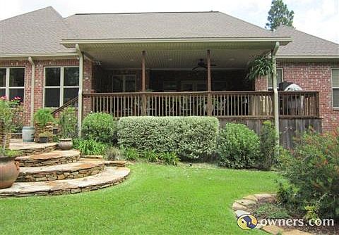 Large covered deck overlooking stacked stone patio & fenced yard