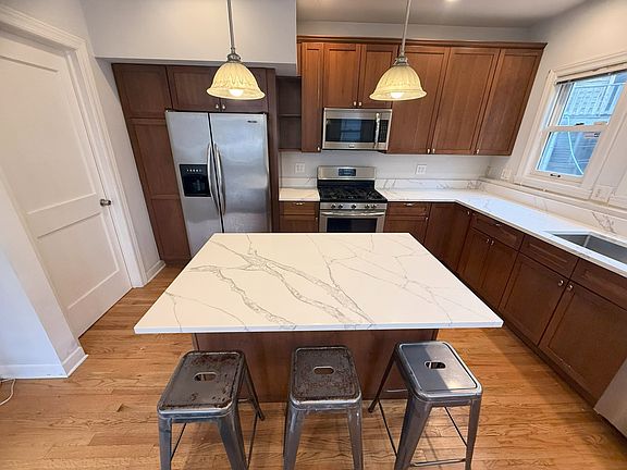 Kitchen with quartz countertops, stainless appliances, walk-in pantry