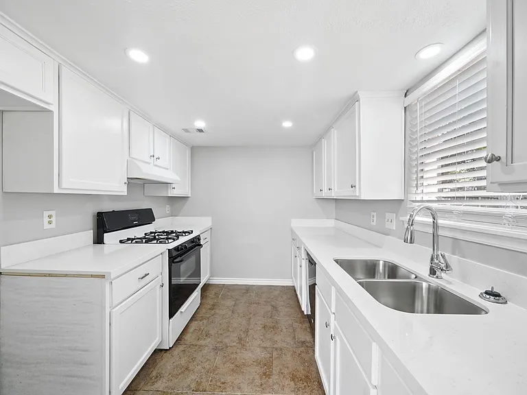 kitchen with new quartz countertops & new sink with hose sprayer. also a new dishwasher.