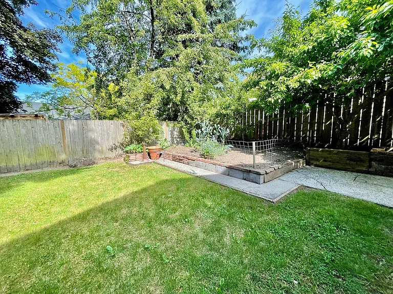 Large, fenced yard with mature fruit trees and garden