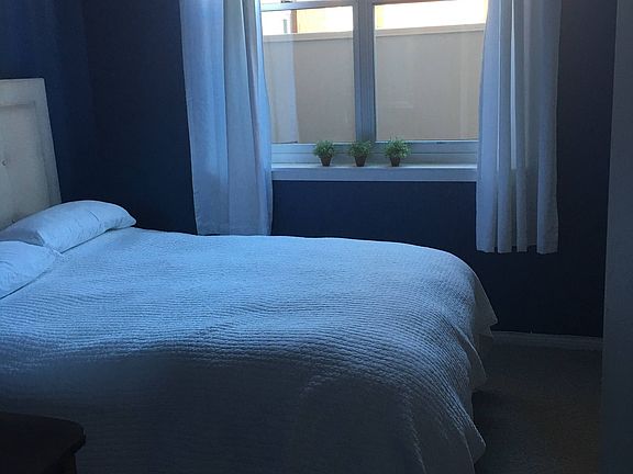 Bedroom with natural light and window covering, 12 foot closed walls