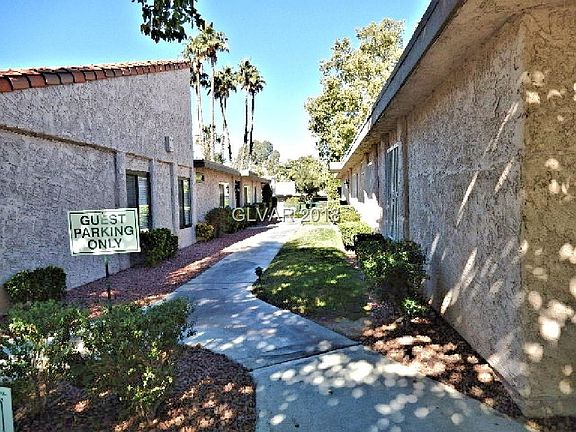 Walkway from street to pool area and to property entrances for properties on left and right in photo.