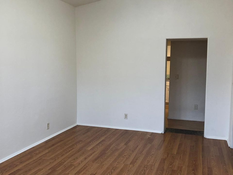 Skylights, ceiling fan and new hardwood floor in living room Door shown leads to kitchen/dining area and back bedroom.