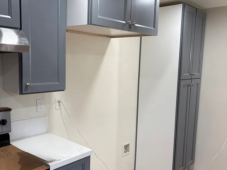 To the left, new stove/oven and cabinets. Refrigerator area and new cabinets, new counter top.