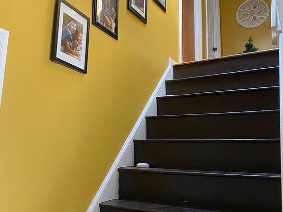 Stairway to three more bedrooms, full bathroom, and office/closet