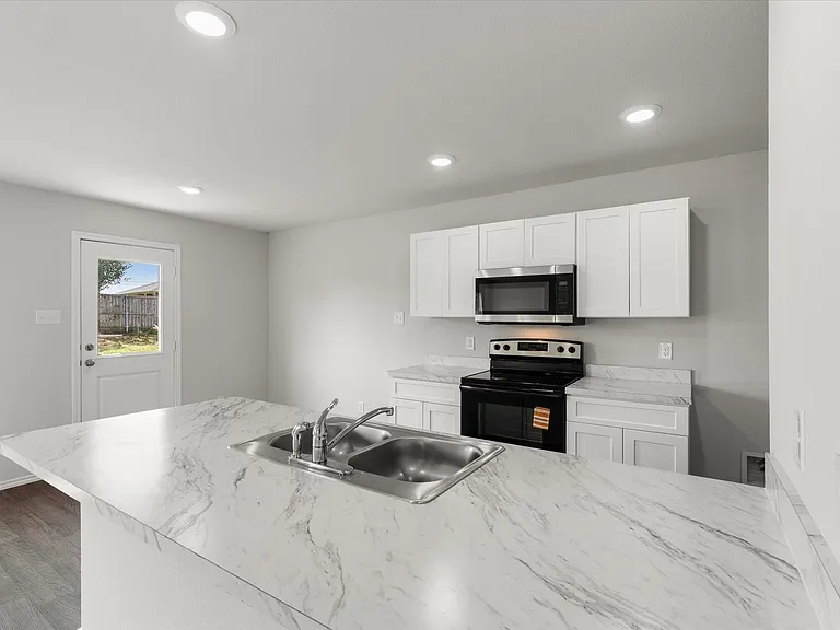 Kitchen featuring a large island with a double basin sink, white cabinetry, integrated microwave, black electric range, and wood-finish flooring