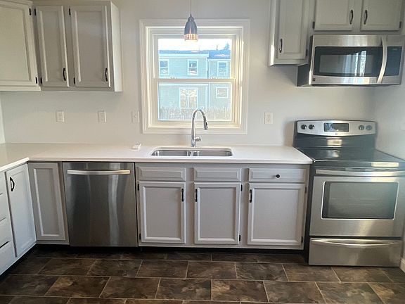 A window over the kitchen sink with a view to the backyard and outside deck.