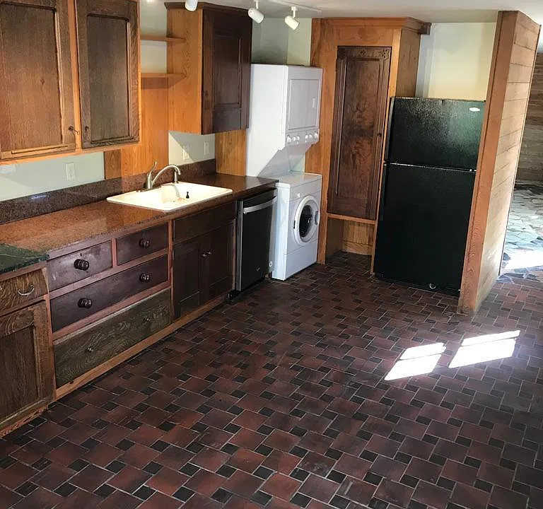 Kitchen with washer/dryer, dishwasher, refrigerator and garbage disposal. Custom cabinets and tile floor.