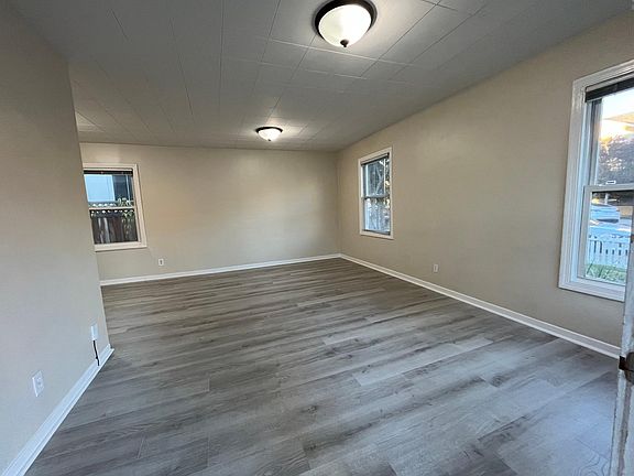 Bright, airy living room features multiple windows and newer luxury vinyl flooring throughout.