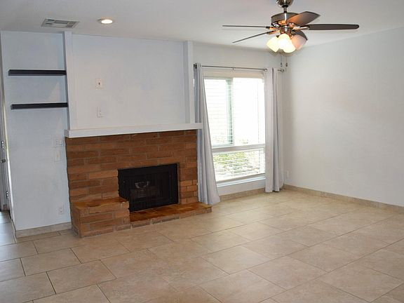 Living room has a gas fireplace. Door to garage is open on the left side.