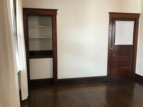 Living room. Shelving unit. Door is the entrance to the apartment from the hall.