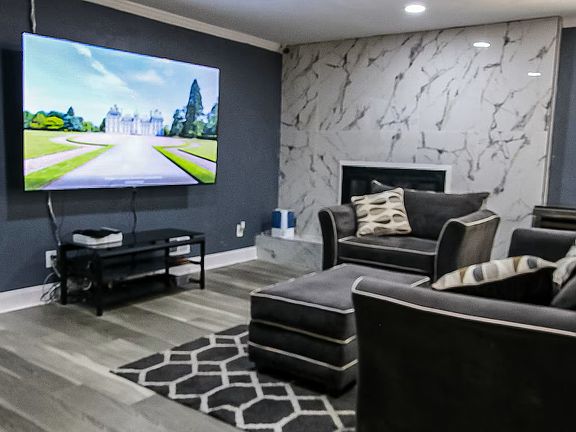Living Room Area with extra large comfy couches and ottoman and a 86 inch Screen TV with Roku included.