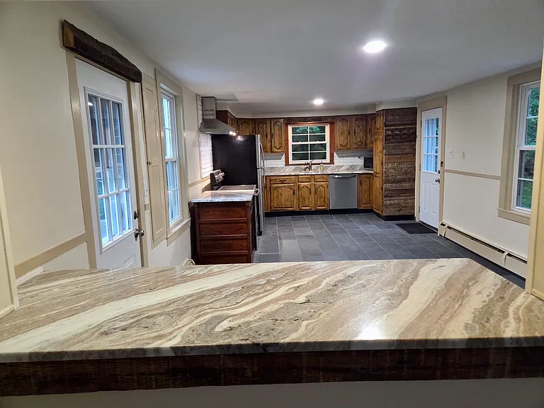 View across kitchen/dining area with granite bar area in foreground