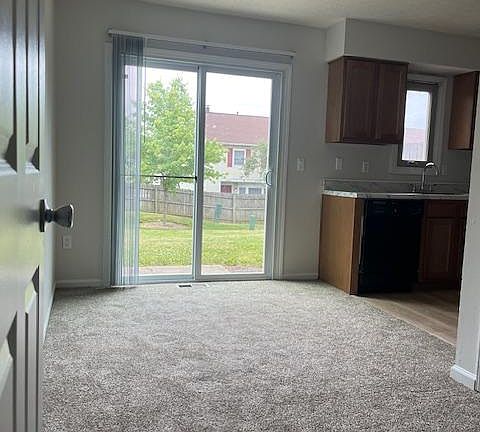 dining room into kitchen overlooking large, maintained yard