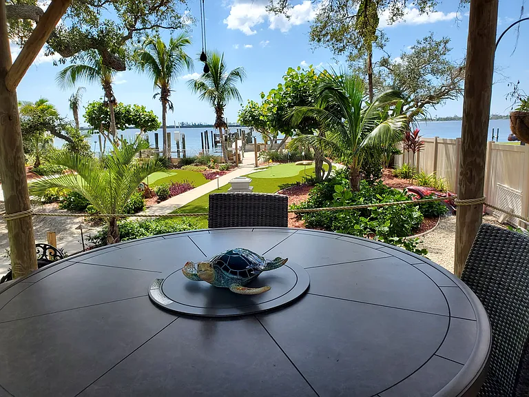 TIKI HUT WITH DINING FIRE PIT TABLETOP OVERLOOKING GARDENS AND BAY