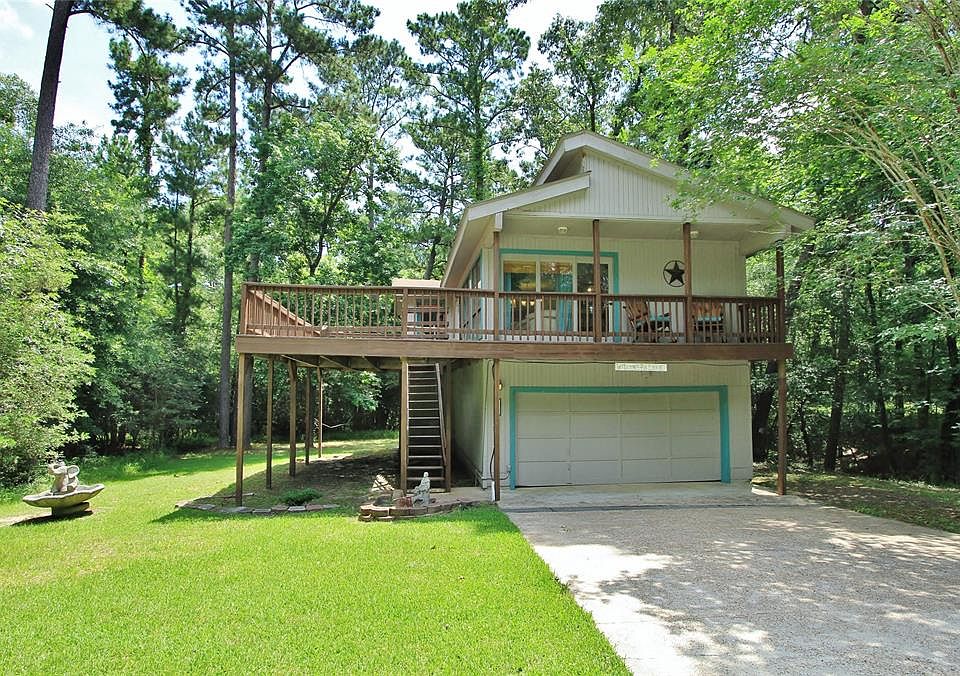 Charming Two Story, Two Bedroom Home is surrounded by trees on all sides for a tranquil setting.