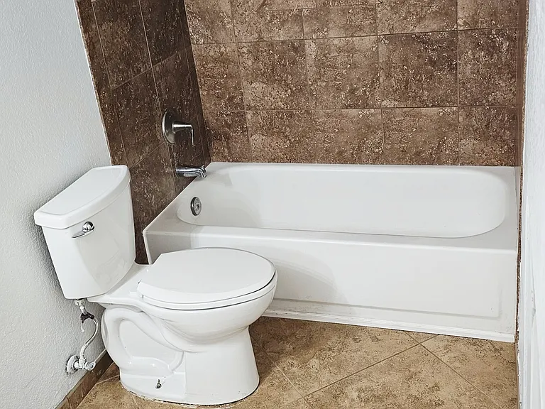 Lower-level bathroom featuring a tiled shower/tub combination, modern finishes, and a clean, well-maintained design.
