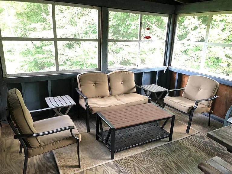 Fully enclosed screened porch with comfy sitting area.