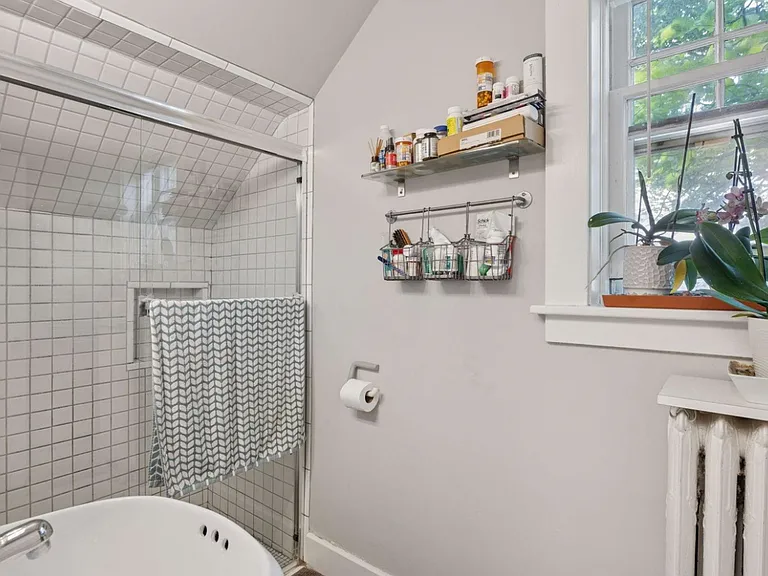 Detailed tiled bathroom with walk-in shower, radiant heat for those cold winter days, and a south-facing window for extra natural light and some bathroom plants! Plenty of storage.