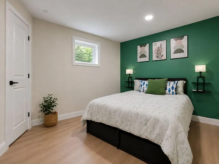 Well-appointed bedroom with a full bed, wall-mounted nightstands, and a window for natural light, plus closet access.